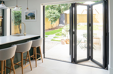 Premium bifold door system shown fully opened, demonstrating concertina operation and slim profile