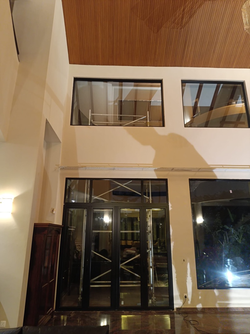 Double-height living void showing EZZO upper clerestory windows and full-height sliding door during installation phase